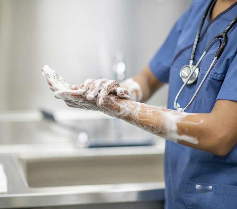 Doctor disinfects hands for surgery